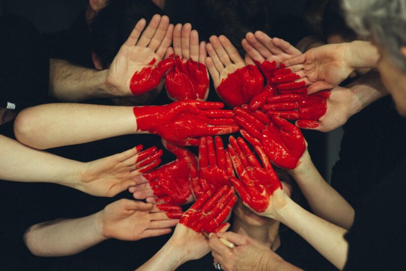 A red hand grouped together with a red heart painted on them